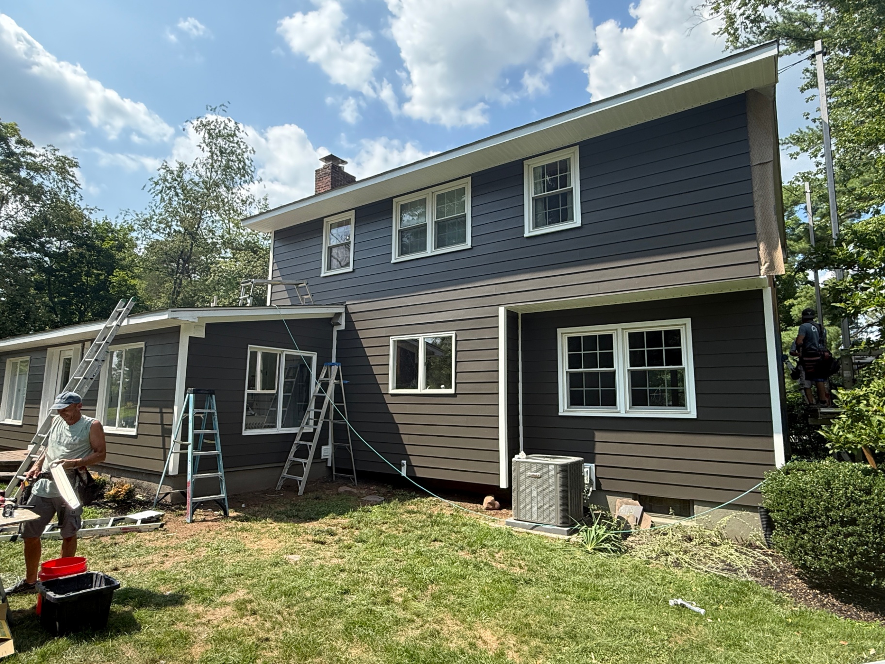 Dark iron gray Hardie siding installation in progress on two-story home
