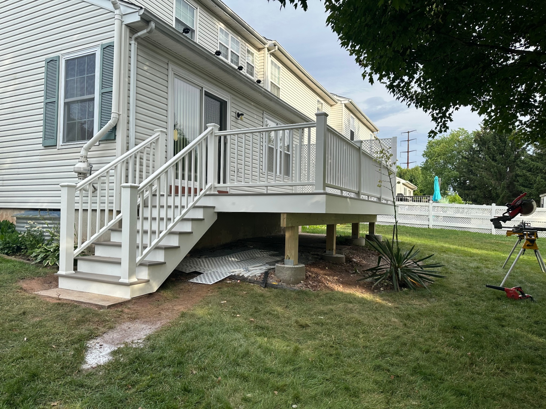 Side view of new elevated composite deck with white railings and stairs