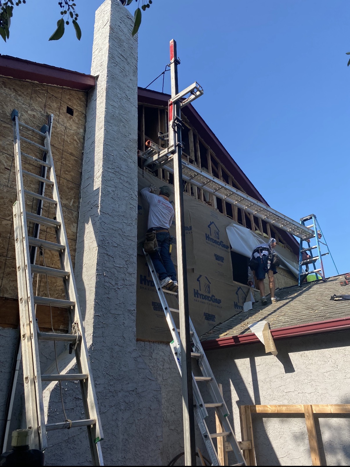 Crew installing siding from ladders